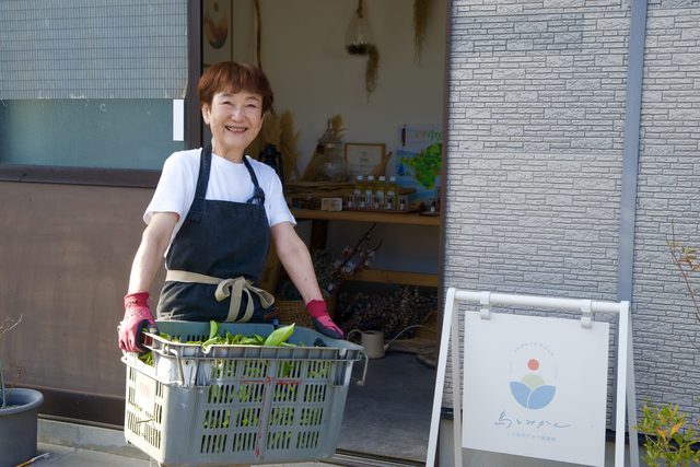 柑橘の葉を入れたかごを抱える母