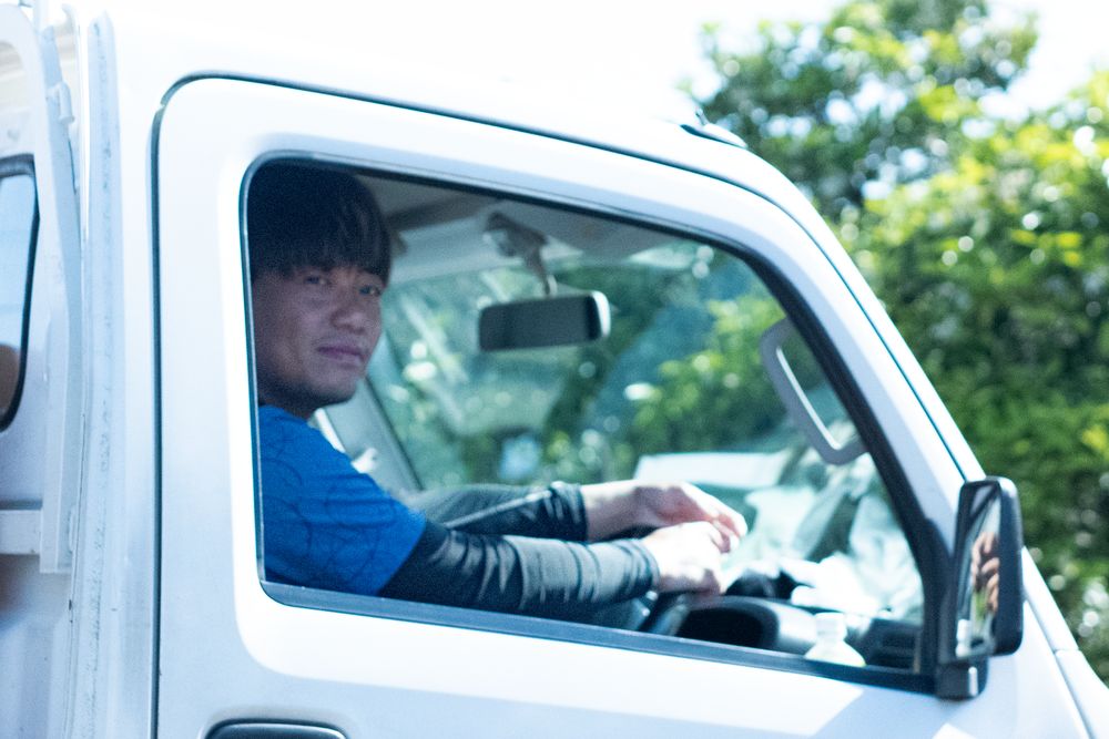 軽トラックで畑をまわる久保さん