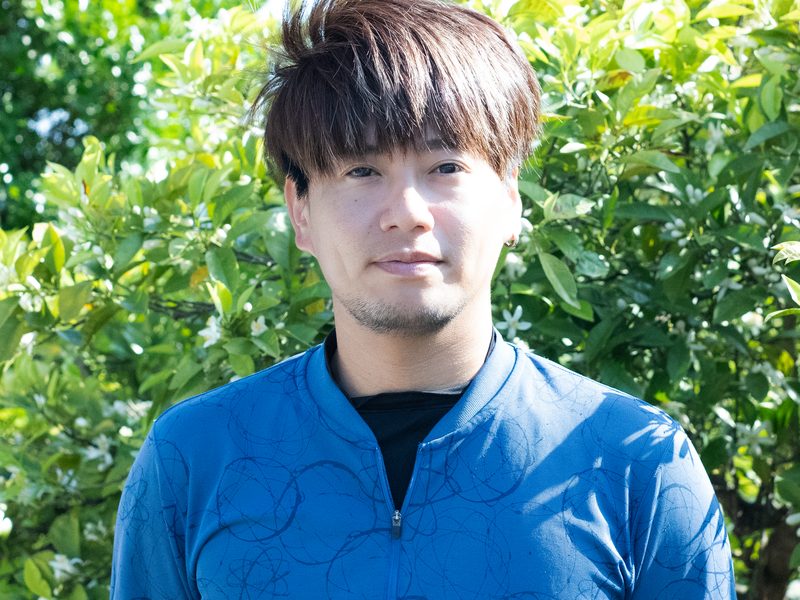 軽トラックの運転席からこちらを見る久保さん